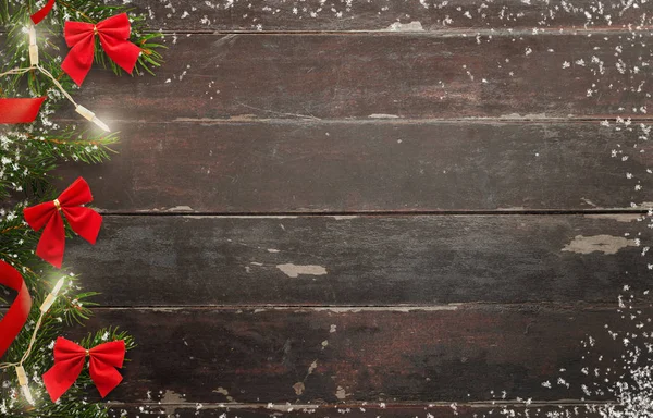 Christmas trä bakgrund med julgran och röda rosetter — Stockfoto