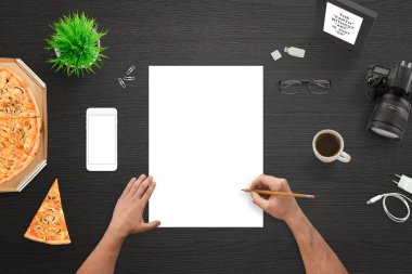 Tasarımcısı veya boş beyaz kağıt üzerine çizim fotoğrafçı. Kamera ve cep telefonu yanında. Siyah çalışma masası Üstten Görünüm.