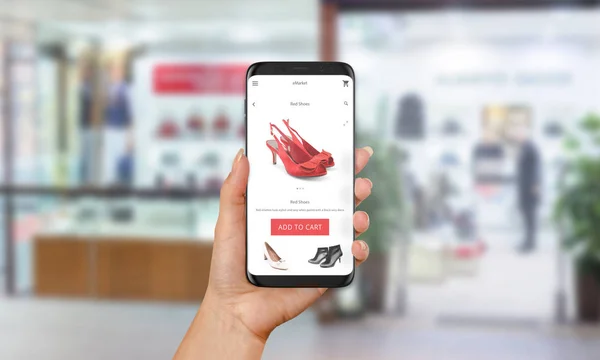 Γυναίκα Αγοράστε κόκκινα παπούτσια σε απευθείας σύνδεση με το κινητό τηλέφωνο. Ε αγορές με την τοποθεσία web ή app. ρούχα και υποδήματα κατάστημα στο παρασκήνιο — Φωτογραφία Αρχείου