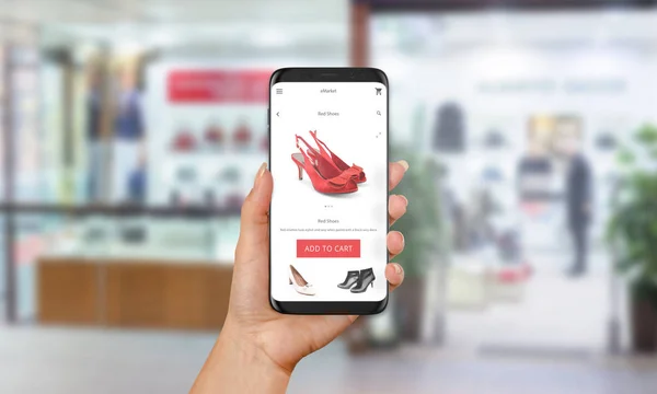 Donna acquistare scarpe rosse online con il telefono cellulare. E shopping con sito web o app. Abbigliamento e calzature negozio sullo sfondo — Foto Stock