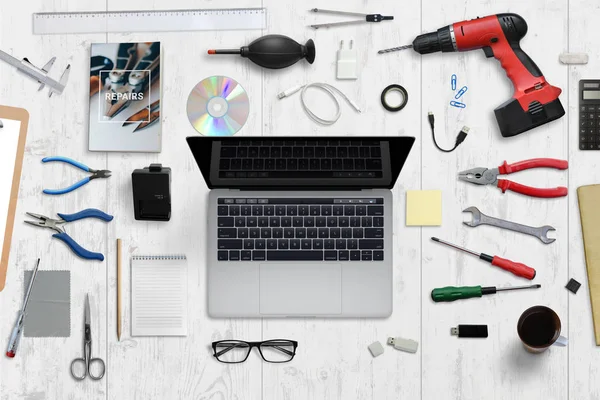 Escritorio de servicio de hardware informático. Ordenador portátil con pantalla en blanco rodeado de herramientas de reparación . —  Fotos de Stock