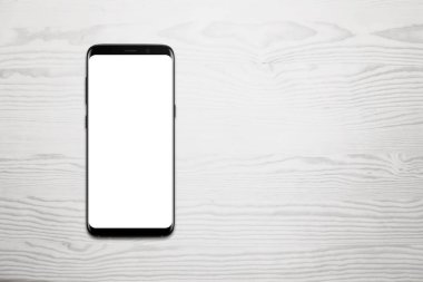 Beyaz ahşap masa metin için boş alan ile siyah cep telefonu