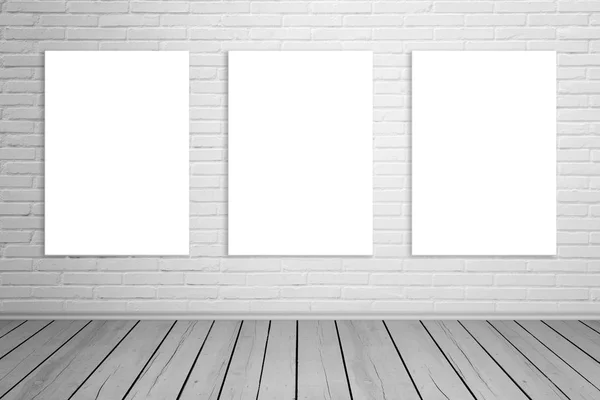 Três telas de arte isoladas na parede de tijolos para maquetes. Espaço vazio na galeria. Piso de madeira . — Fotografia de Stock