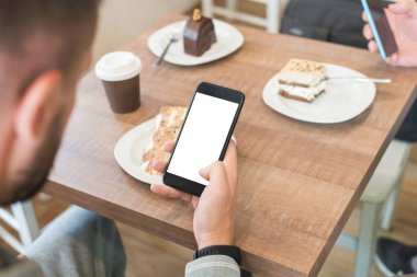 İş ile izole perde mockup için modern akıllı telefon üzerinde bir adamın. Kek ile kahve masası