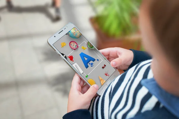 Chlapec souhlasí písmena na mobilní aplikaci a učit se prostřednictvím hry — Stock fotografie