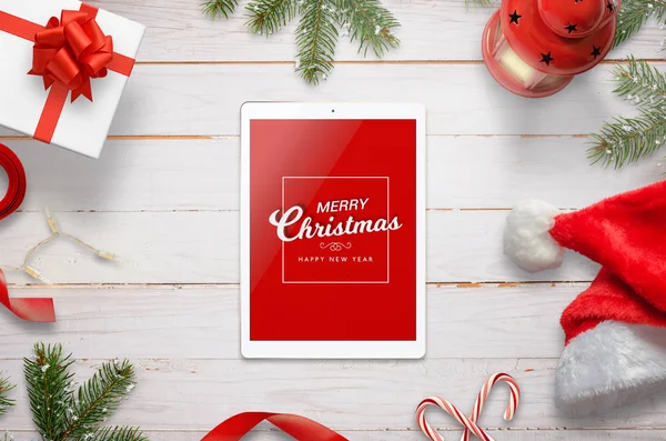 Vista superior de la tableta con mensaje de Feliz Navidad rodeado de decoraciones de Navidad — Foto de Stock