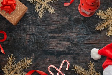 Noel süslemeleri ile arka plan. Boş alan için metin ortada. Noel ağacı, hediyeler, lolipop ve Santa şapka kompozisyonu. Üstten Görünüm.