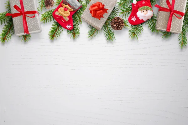 Karácsonyi Háttér Ajándékok Zokni Pinecones Fenyő Ágak Tetején Tiszta Fehér — Stock Fotó
