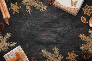 Noel altın renkli süslemeleri siyah ahşap tahta üzerinde. Boş alan için metin ortada. Üstten Görünüm.