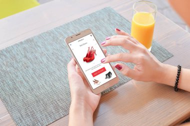 Kadın Ayakkabı online satın kırmızı. Mobil uygulaması veya web sitesi ekran üzerinde. Tablo ve suyu içinde geçmiş.