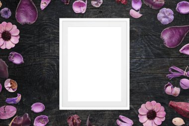 Resim çerçevesi siyah ahşap masa mor çiçek süslemeleri ile çevrili.