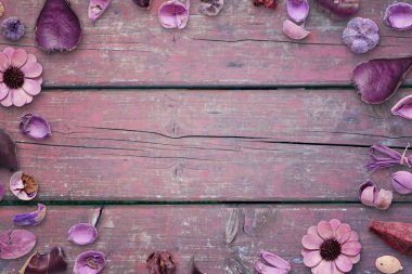 Metin, fotoğraf veya ürün tanıtımı için ortada boş alan ile ahşap masasında pembe, mor çiçek süslemeleri.