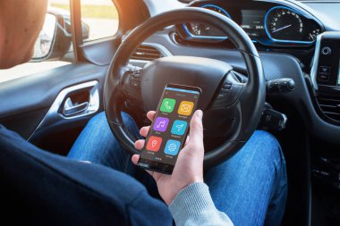 Smartphone bir araba sürücüsü elinde. Bir akıllı araç app navigasyon, ekran gösterir seyahat planlama, müzik, telefon ve sesli mesaj.