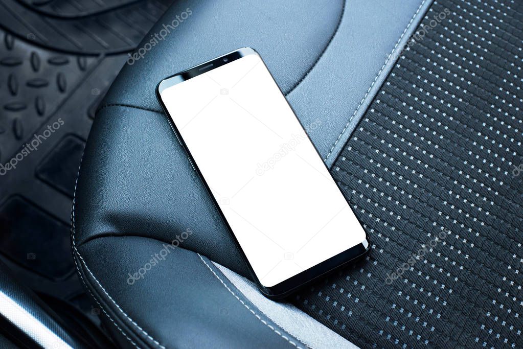 Mobile phone on the leather seat of a car. Isolated screen for app or web site mockup promotion.