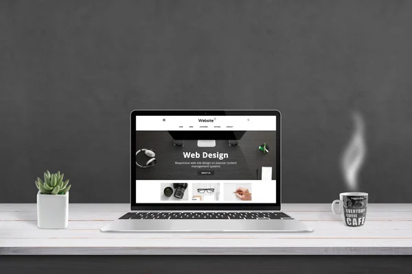 网页设计机构的演示与响应 平面网站设计的笔记本电脑显示 杯咖啡和平板旁边 背景黑墙 — 图库照片