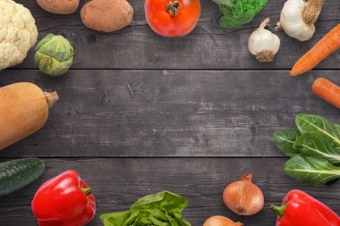 Taze sebze bileşimi bir ahşap yüzeye yayılmış. Kopya alanı orta.