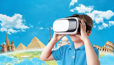 Sanal gerçeklik kulaklığı kullanma kavramı. Elinde sanal gerçeklik gözlüğü tutan çocuk. Arka planda dünyaca ünlü manzaralı bir dünya var. Uzayı buraya kopyala.