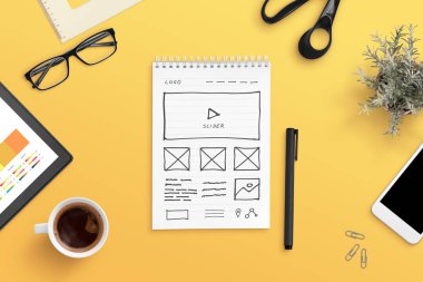 Web tasarım stüdyosu konsepti ile web sitesi taslağı kağıt üzerinde. Turuncu çalışma masası, düz yatak, üst görünüm kompozisyonu.