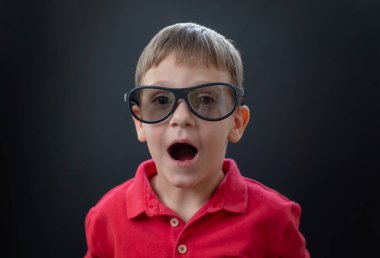 Sinema 3D gözlüklü, neşeli yüzlü bir çocuk. Arka plan.