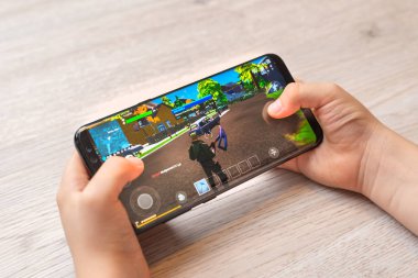 Saraybosna, Bosna-Hersek - 29 Kasım 2019: Fortnite serbest dövüş kraliyet maçı, çağdaş akıllı telefonda çocukların yakın çekimlerinde