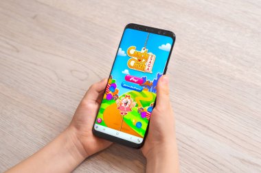 Saraybosna, Bosna-Hersek - 30 Kasım 2019: Samsung Galaxy S9 'u elinde tutan çocuk artı Candy Crush Saga video oyunu yakın plan