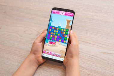 Saraybosna, Bosna-Hersek - 30 Kasım 2019: Candy Crush Saga bulmaca video oyunu çağdaş akıllı telefonda çocukların yakın çekimlerinde