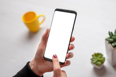 Kadın eliyle yakın plan telefon modeli. İzole ekran uygulaması veya web sitesi sunumu