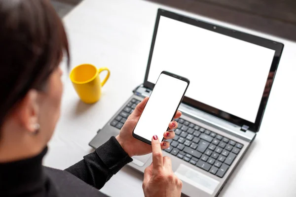 Phone and laptop mockup. Woman holding smart phone with isolated screen over the laptop with isolated screen for app or web site presentation