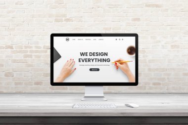 Ofiste web tasarım ajansı sayfası olan modern bilgisayar görüntüsü, stüdyo masası. Düz tasarım konsepti. Arka planda tuğla duvar ile modern düz tasarım iç mimarisi