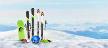 Kayak ekipmanları bir dağın tepesindeki kara sabitlendi. Kış tatili ve kar sporları kavramı. Arka planda karlı dağ zirveleri