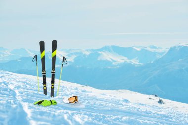 Karda kayak ekipmanları. Kayak yamacı ve arka plandaki dağ zirveleri a. Kış tatili ve kış sporları konsepti