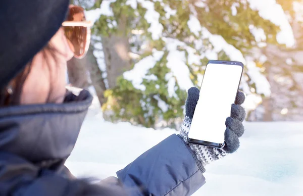 Phone in girl hand. Winter time. Isolated screen for mockup, app design promotion. Snow in background