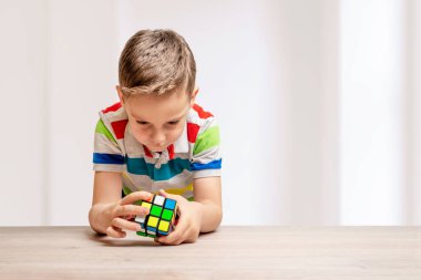 Çocuk bir rubik küp çözüyor. Hız küpü bulmaca yarışması kavramı. Uzayı buraya kopyala