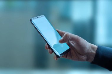 Akıllı telefon tutan adam. Soyut tehnoloji arka planına sahip yakın çekim sahnesi. Genel bağlantı kavramı