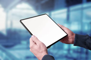 Model, uygulama ya da web sitesi promosyonu için izole edilmiş ekranı olan tablet adamın elinde. Arka planda pencereler oluşturma işi