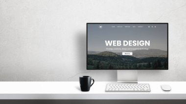 Bilgisayar ekranında web tasarım stüdyo portföyü sayfası. Duvarında kopya alanı olan ofis masası