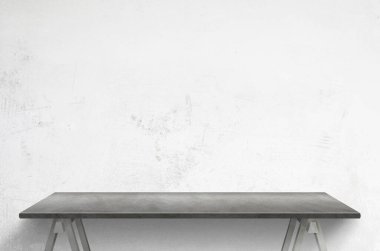 Beyaz beton duvarın önündeki temiz gri masa