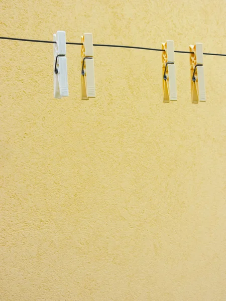 Plastové kolíčky na prádlo na žlutém podkladu — Stock fotografie
