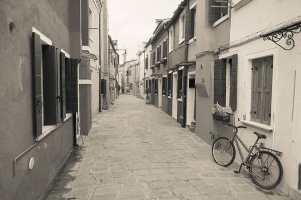 Altes fahrrad, das lange an einer außenwand in burano island, venedig abgestellt ist (vintage effect) — Stockfoto