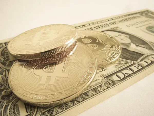 Деякі Bitcoin і один долар законопроекту в білому тлі — стокове фото