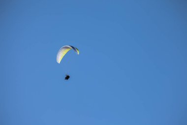 Güneşli bir günde, İtalya 'daki Dolomitler üzerinde mavi gökyüzünde tek başına yürüyen bir adam.