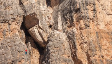 Dolomitlerdeki Cinque Torri bölgesinde kaya tırmanışçıları dikey bir uçurum üzerinde hareket halindeler
