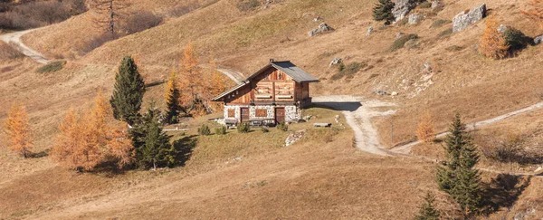 Odizolowana górska kabina wśród żółtych pastwisk jesienią wśród włoskich Dolomitów — Zdjęcie stockowe