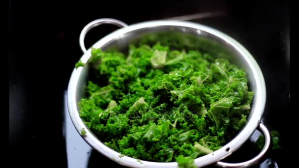 Μαγειρεμένα πράσινα λάχανο σε ένα σουρωτήρι σε μαύρο — Αρχείο Βίντεο