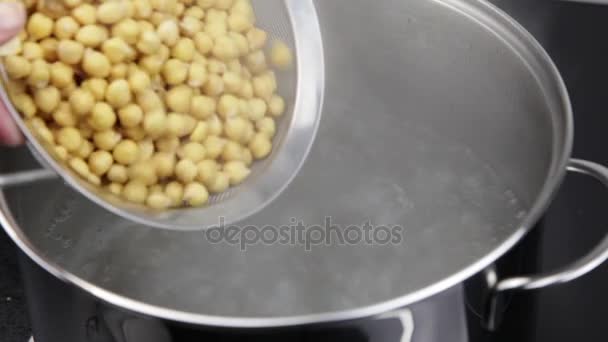 Añadir garbanzos a agua hirviendo en la estufa — Vídeos de Stock