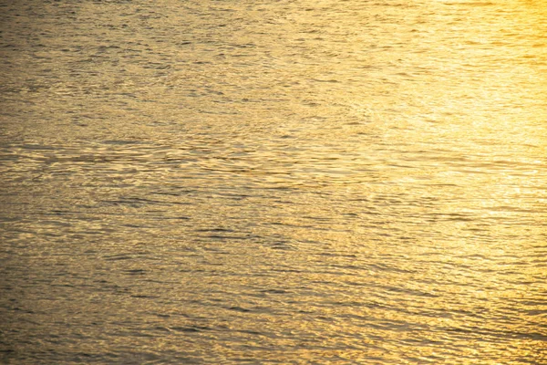 Blurred of Golden rippled water surface an the sunrise or sunset. — Stock Photo, Image