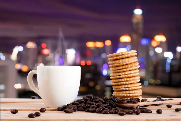 Кофе и крекер закуски на столе над Cityscape боке, размытые фото, городской пейзаж в сумерки — стоковое фото
