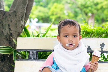 Asyalı çocuk eatting duygu mutlu ve lezzetli dondurma