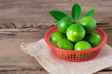 rustik ahşap arka plan üzerinde kırmızı kova kireç limon. kopya spa