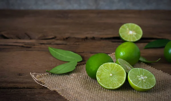 bir kireç limon rustik ahşap arka plan üzerinde çadır bezi ile.